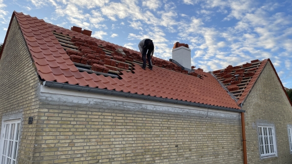 nyt tag med røde tagsten monteres af tømrere